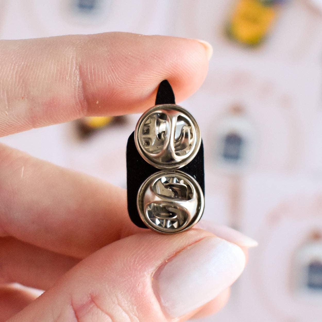 Back of enamel pin showing metal clasp for attaching to clothing or accessories