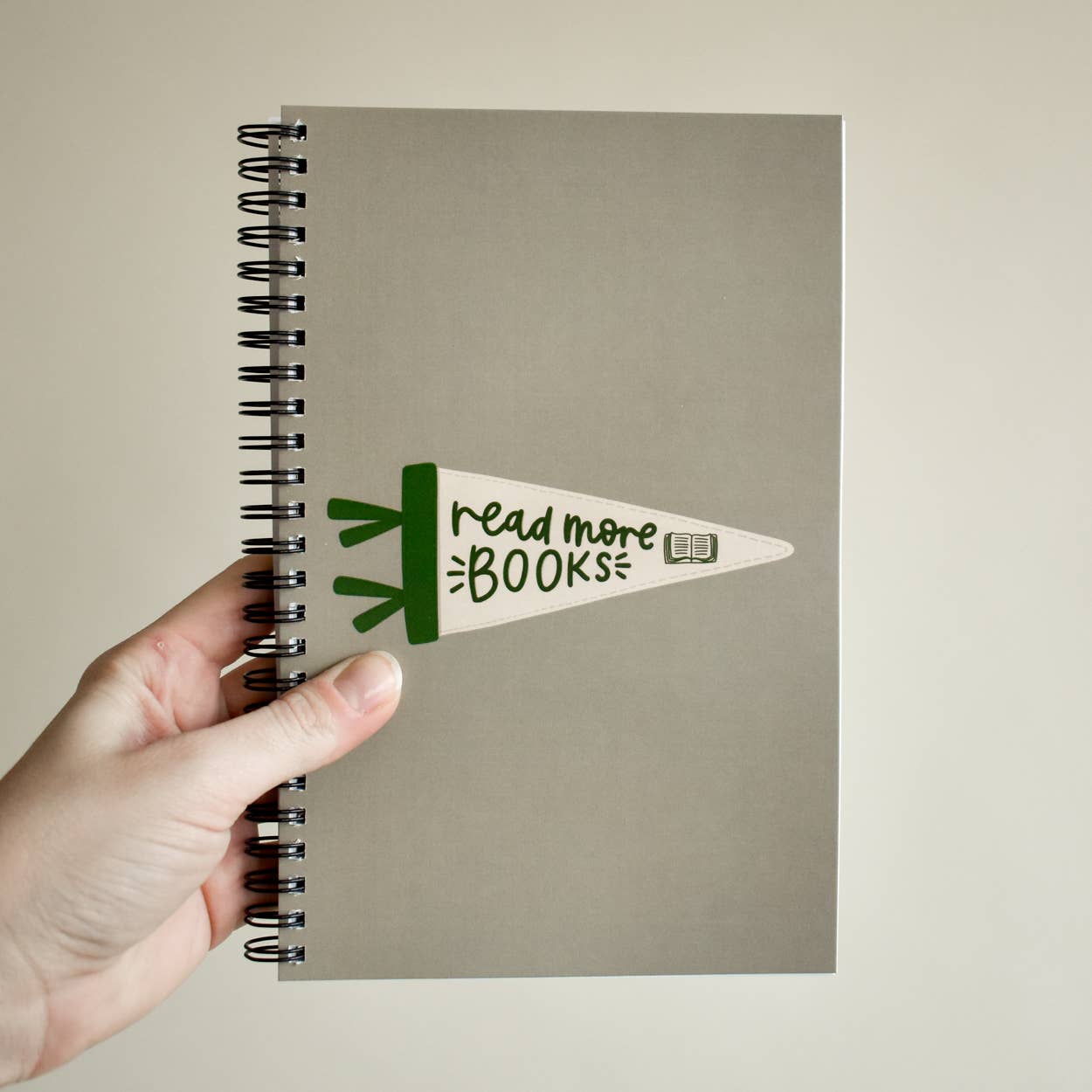 Gray spiral-bound book with 'Read More Books' slogan and book graphic