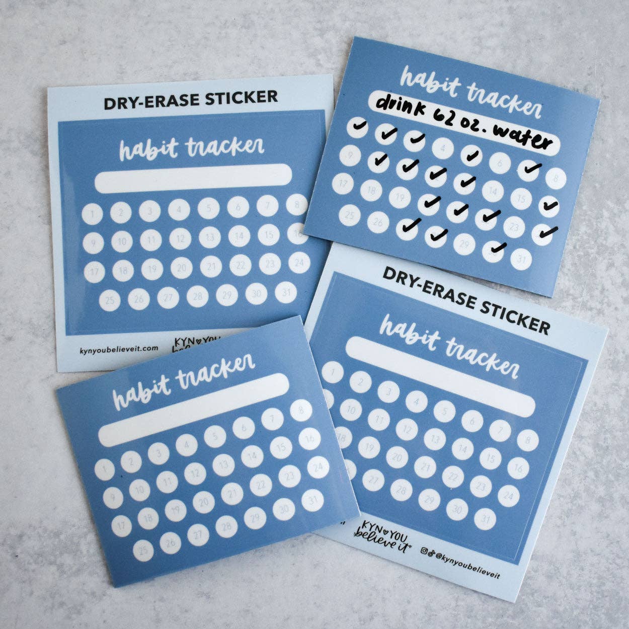 Four blue habit tracker calendar stickers on a gray surface