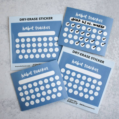 Four blue habit tracker calendar stickers on a gray surface