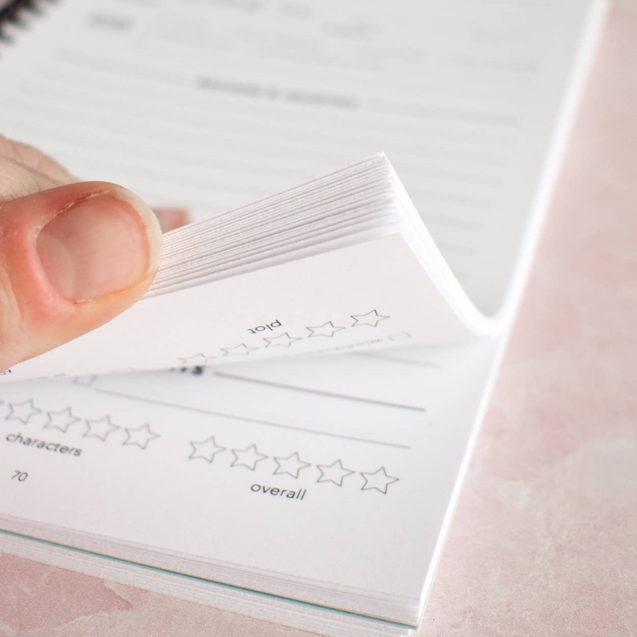 Hand holding a sheet of star rating cards with various ratings.