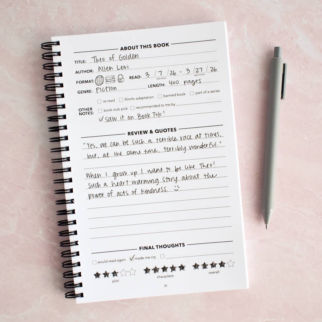 Notebook with reading notes on a pink background